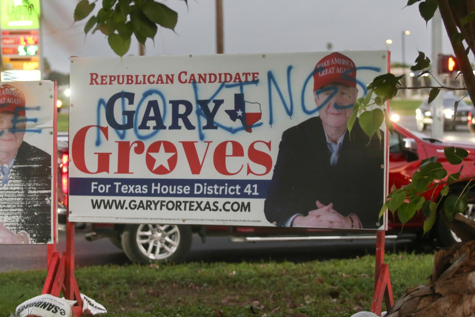 加里·格罗夫斯 (Gary Groves) 在广告活动中戴着 MAGA 帽子。广告上的涂鸦写着 "没有国王。"